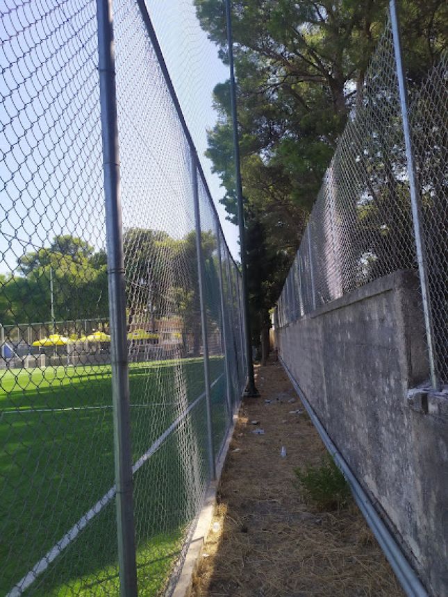 Περιμετρική περίφραξη τοποθετημένη με στιβαρούς μεταλλικούς στύλους για μέγιστη ασφάλεια, κατάλληλη για υπαίθριους αθλητικούς χώρους